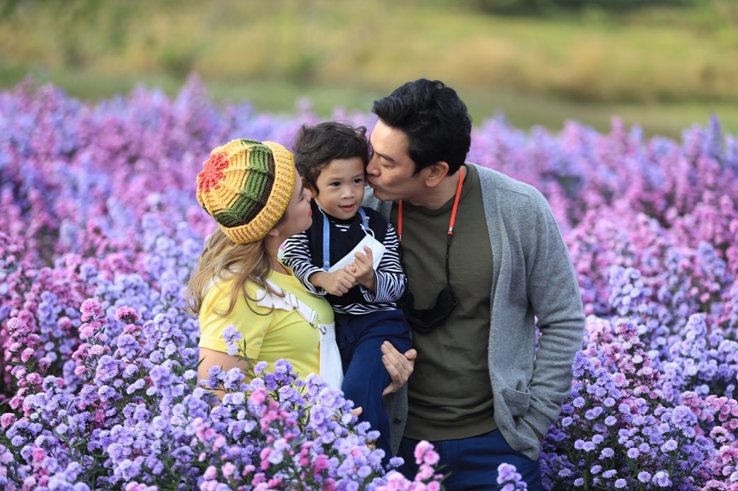 ชาคริต แย้มนาม แอน ภัททิรา น้องโพธิ์ ยืนอยู่กลางทุ่งดอกไม้ จังหวัดเชียงราย