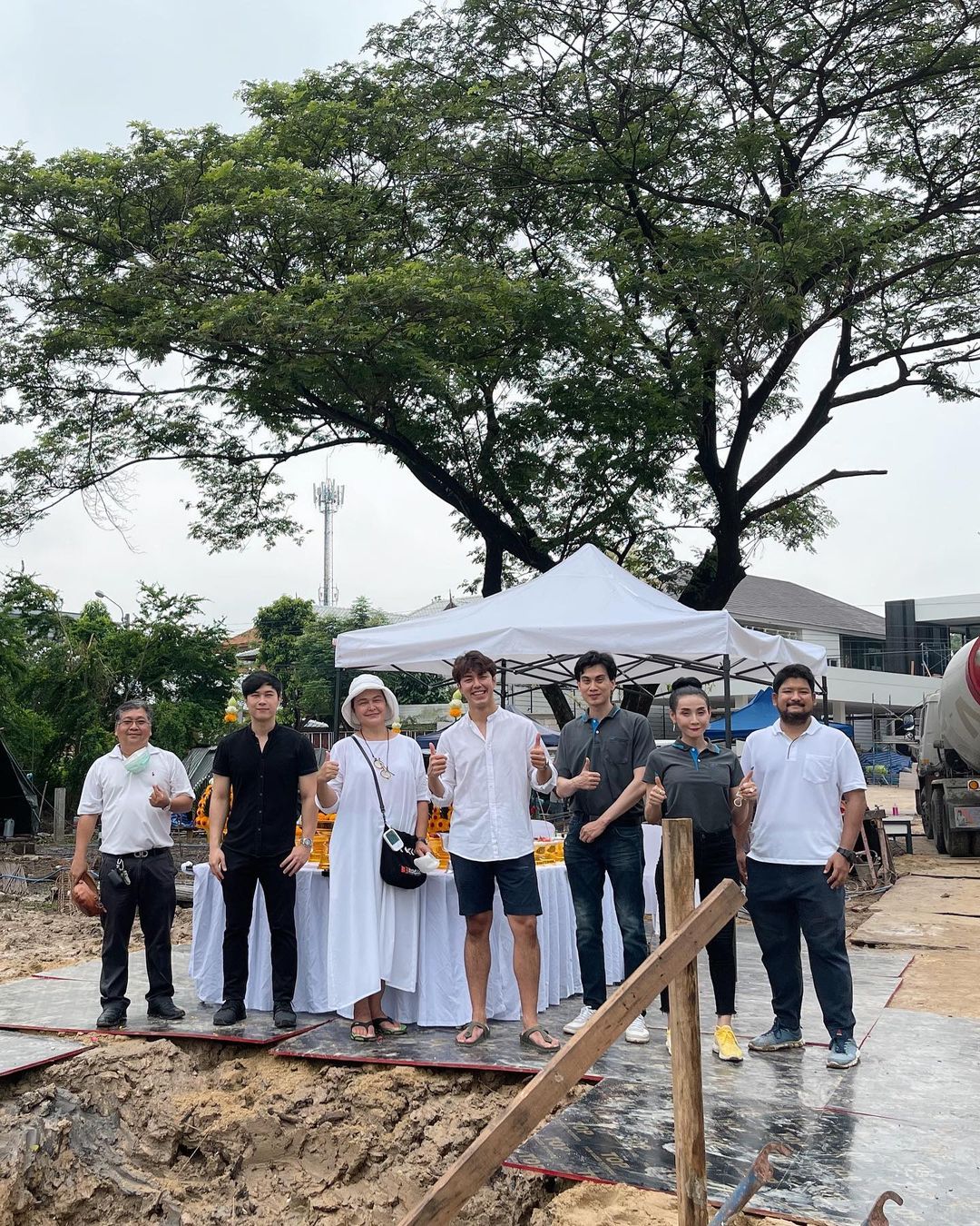 นาย ณภัทร เสียงสมบุญ และแม่ หมู พิมพ์ผกา ถ่ายรูปร่วมกับสถาปนิก และผู้รับเหมาก่อสร้าง ในพิธีลงเสาเอก